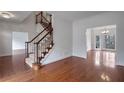Inviting foyer featuring gleaming hardwood floors, a staircase, and an elegant chandelier at 12090 Lonsdale Ln, Roswell, GA 30075