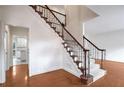 Elegant foyer features hardwood floors and a staircase with decorative wrought iron railing at 12090 Lonsdale Ln, Roswell, GA 30075