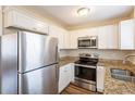Well-lit kitchen showcasing stainless steel appliances, granite countertops, and white cabinets at 3499 Villa Se Cir, Atlanta, GA 30354