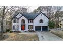 Charming two-story brick house with black trim, a two-car garage, and a neatly landscaped yard at 559 Fairway Dr, Woodstock, GA 30189