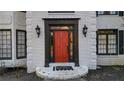 Close-up of a vibrant red front door with sidelights and decorative hardware, welcoming guests at 559 Fairway Dr, Woodstock, GA 30189