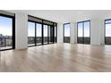 Open living space with hardwood floors, large windows, and black trim offering abundant natural light and city views at 2425 Peachtree Rd # 1806, Atlanta, GA 30305