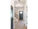 Inviting entryway with wood floors, a staircase, a stylish light fixture and a black front door at 2646 Radvell Ct, Decatur, GA 30034