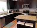 Well-equipped kitchen featuring granite countertops, stainless steel appliances, and dark wood cabinetry at 1101 Senator Rd, Douglasville, GA 30134