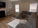 Cozy living room with a fireplace, wood floors, and a comfortable sectional sofa at 1101 Senator Rd, Douglasville, GA 30134