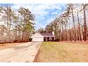 Inviting curb appeal featuring a one-story home with a long driveway and lush front yard at 122 Lakepointe Court, Stockbridge, GA 30281