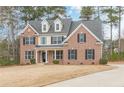 Charming two-story brick home with black shutters, dormer windows, and a spacious front lawn at 190 Holcomb Ct, Fayetteville, GA 30215