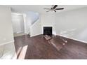 Open-concept living room featuring new flooring, fireplace, ceiling fan, and staircase access at 3160 Sable Trl, Atlanta, GA 30349