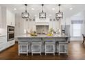 Modern kitchen featuring an island with seating, stainless steel appliances, and elegant pendant lighting at 10635 N Edgewater Pl, Johns Creek, GA 30097