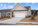 Home with a well-manicured lawn, and a white two-car garage under a blue, cloudy sky at 1723 Juniper Berry Way, Loganville, GA 30052