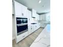 Modern kitchen boasts white cabinetry, stainless steel appliances, and a large island with countertop at 718 Crossroad Ct, Powder Springs, GA 30127