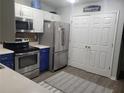 Kitchen area with stainless steel appliances, white upper and blue lower cabinets, and light vinyl floors at 104 Worthy Drive, Mcdonough, GA 30252