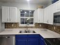 Kitchen area featuring a stainless steel sink, white upper cabinets, and bronze backsplash at 104 Worthy Dr, Mcdonough, GA 30252