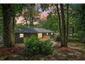 A backyard view featuring mature trees, stone wall, and a new wooden deck at 2210 Bolling Brook Sw Dr, Atlanta, GA 30311