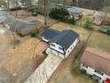 Aerial view of updated home with black roof and two-car garage, nestled among mature trees at 2385 Tiffany Pl, Decatur, GA 30035