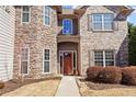 Inviting front entrance with a stone facade and a red door, framed by manicured bushes at 3830 Deer Run Dr, Cumming, GA 30028