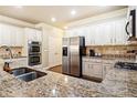 Modern kitchen with stainless steel appliances, granite countertops, and white cabinets at 3830 Deer Run Dr, Cumming, GA 30028