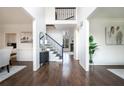 Inviting foyer with dark wood floors, iron-railed staircase, and natural light creates a grand entrance at 1165 Pin Oak Ct, Cumming, GA 30041