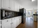 Modern kitchen with granite countertops, sleek white cabinets, and stainless steel appliances at 1165 Pin Oak Ct, Cumming, GA 30041