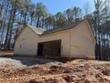 Side view of new home showing a spacious garage and light siding, with a backdrop of tall trees at 2117 Hwy 101 N, Dallas, GA 30157