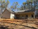 Rear exterior of new construction home featuring light siding and covered back porch, nestled in a wooded area at 2117 Hwy 101 N, Dallas, GA 30157