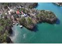 Aerial view of home on the lake surrounded by lush trees, offering a serene waterfront experience and private boat storage at 3330 Chimney Point Dr, Cumming, GA 30041