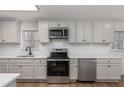 Bright kitchen featuring stainless steel appliances, white cabinetry, and modern countertops at 365 Cowan Rd, Covington, GA 30016