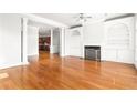 Bright living room with hardwood floors, fireplace, built-in shelving, and elegant pillars at 2300 Peachford Rd # 3411, Atlanta, GA 30338