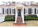 Inviting front entrance features brick steps, white railings, updated lighting and black front door at 2911 N Hills Ne Dr, Atlanta, GA 30305