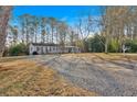 Exterior view of house with large gravel driveway and wooded surroundings at 6106 Misty Valley Se Dr, Acworth, GA 30102