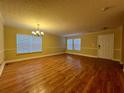 Bright living room with hardwood floors, neutral paint, a chandelier, and large windows at 2098 Cutleaf Creek Rd, Grayson, GA 30017