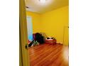 Bedroom featuring wood floors, a window with blinds, and bright yellow walls at 2809 Arendel Dr, Lawrenceville, GA 30044