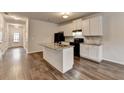 Well-lit kitchen with center island, granite counters, and stainless appliances, adjacent to entry hall at 1797 Old Dogwood, Jonesboro, GA 30238