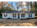 Charming single-story home with light blue siding, dark shutters, and a welcoming front porch at 1974 Young Rd, Lithonia, GA 30058