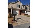 Exterior view of the townhome, featuring a brick facade, and a shared driveway with two mailboxes at 233 Tara Commons Walk, Loganville, GA 30052