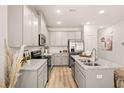Spacious kitchen featuring sleek countertops, stainless steel appliances, stylish cabinetry, and hardwood floors at 9450 Cedar Grove Ct # 332, Jonesboro, GA 30238