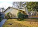 Charming home featuring well maintained lawn and landscaping, with a paved walkway to the side entrance at 6929 Hickory Log Rd, Austell, GA 30168