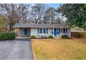 Charming single-story home with gray siding, blue accents, covered carport, and a well-maintained lawn at 3351 Creatwood Se Trl, Smyrna, GA 30080