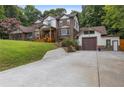 Elegant brick home featuring a covered front porch and a detached garage with stone accents at 3996 Spalding Ln, Atlanta, GA 30350