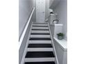 Freshly painted stairway with white trim and black stairs, leading to a landing at 4244 River Green Nw Dr # 111, Atlanta, GA 30327