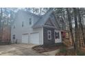 Two-story home with a two-car garage, stone accents, and mature trees at 488 Morris Rd, Hiram, GA 30141