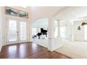 Formal living room with hardwood floors, grand piano, columns, and ample natural light at 2322 Norbury Se Cv, Smyrna, GA 30080