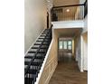 Grand foyer features hardwood floors, staircase with black railings, and modern light fixture at 9137 Loxford St, Lithia Springs, GA 30122