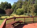 A red wooden deck provides nice views of the lush backyard at 2500 Woodward Rd, Atlanta, GA 30349
