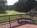 A wooden deck with a bench seat provides beautiful views of the expansive back yard at 2500 Woodward Rd, Atlanta, GA 30349
