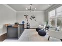 Bright home office featuring a modern light fixture, clean desk and two sitting chairs at 4681 Gablestone Dr, Hoschton, GA 30548