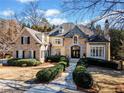 Beautiful home with manicured shrubs leading to a covered front entry with stone and beige accents at 5655 Cross Gate Dr, Atlanta, GA 30327