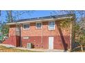 Back exterior showcasing brick, access to the basement, and windows to the upper levels at 2413 Hillside Ave, Decatur, GA 30032