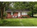 Quaint brick home with a lush green lawn, mature trees, and inviting front entrance at 2413 Hillside Ave, Decatur, GA 30032