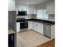 Modern kitchen with stainless steel appliances, black granite counters, and white cabinets at 2413 Hillside Ave, Decatur, GA 30032